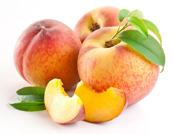 Ripe peach fruit with leaves and slises Royalty Free Stock Photos