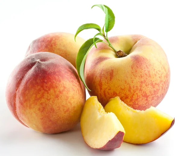Mogen persika frukt med blad och slises — Stockfoto