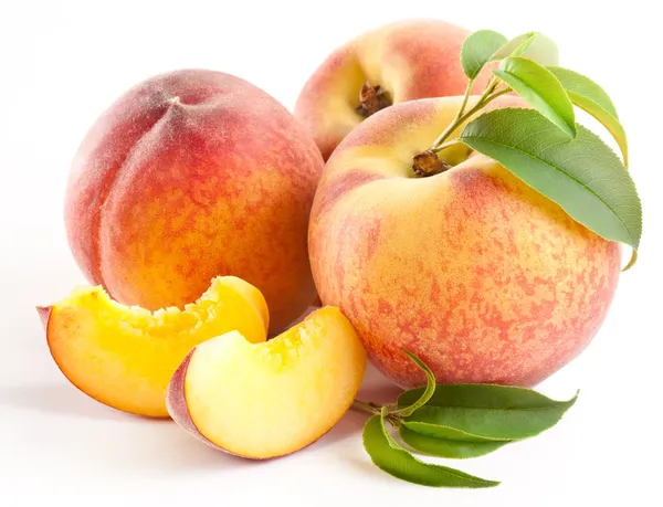Спелые персиковые фрукты с листьями и ломтиками — стоковое фото