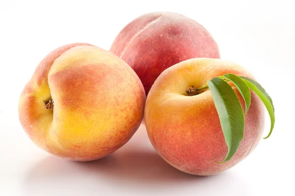 Three ripe peach with leaves Royalty Free Stock Images