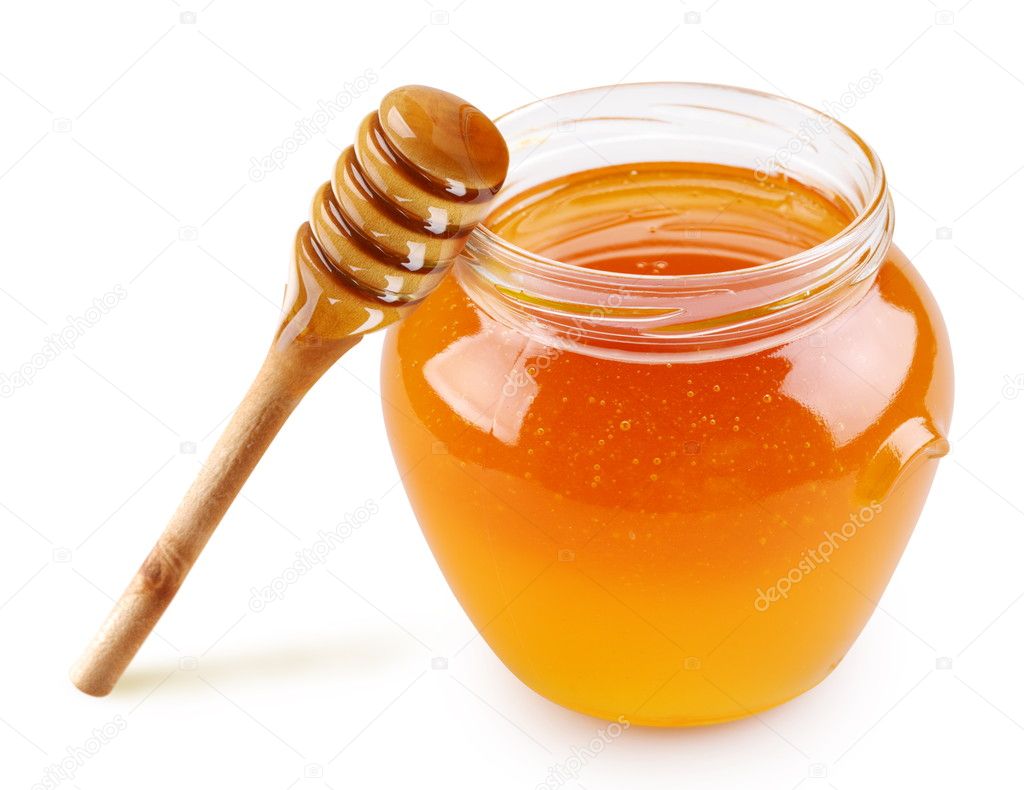 Honey in a glass jar with a stick