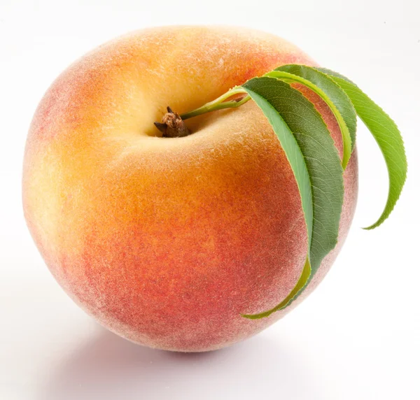 Спелый персик с листьями — стоковое фото