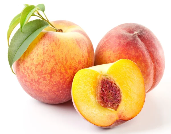 Rijp perzik fruit met bladeren en slises — Stockfoto