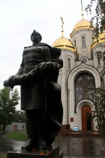 Monumento de bronze e igreja — Fotografia de Stock