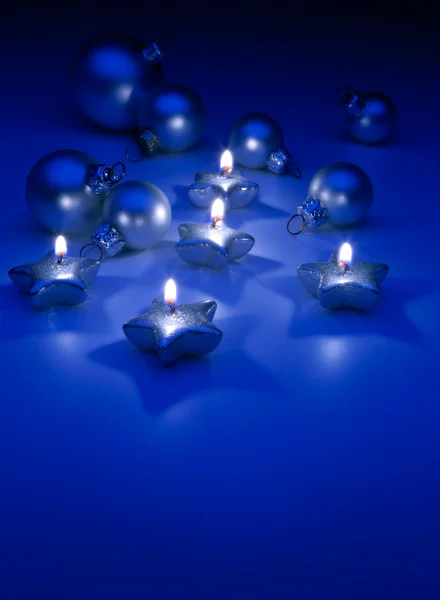 Art Christmas candles and ornaments on a blue background — Stock Photo, Image