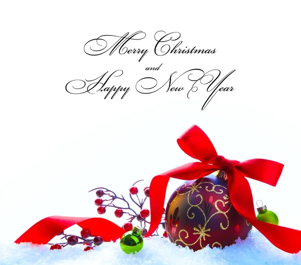Красный рождественский шар с лентой и луком на белом снегу — стоковое фото