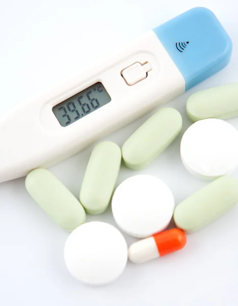 Einige medizinische Pillen und digitales Thermometer — Stockfoto