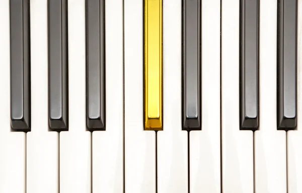 Piano with a gold key — Stock Photo, Image