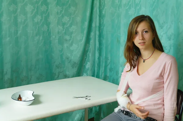 Печальная девушка с перевязанной рукой пациентки в клинике — стоковое фото