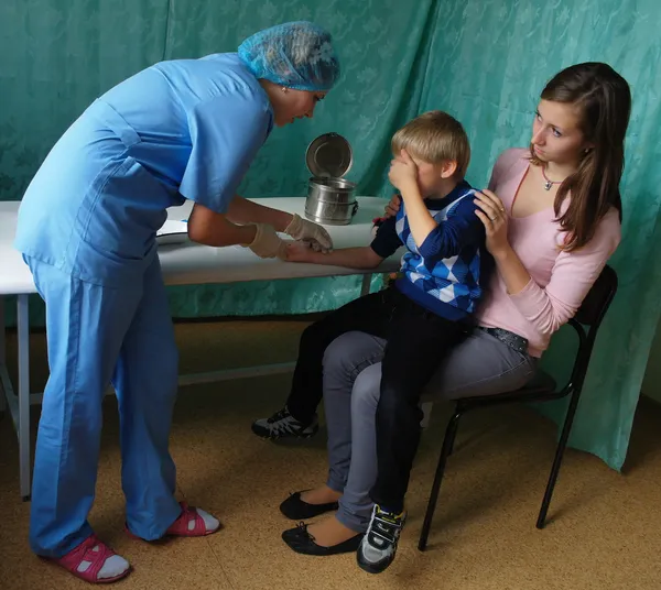 Un médico de la clínica hace que la jeringa para inyección sea para niños Fotos de stock