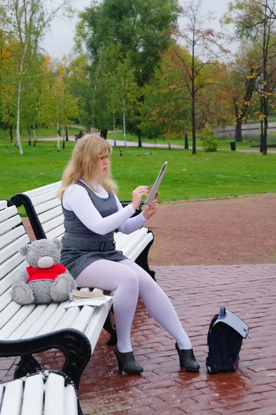 The schoolgirl sitting on a bench and draws on the album — Stock Photo, Image