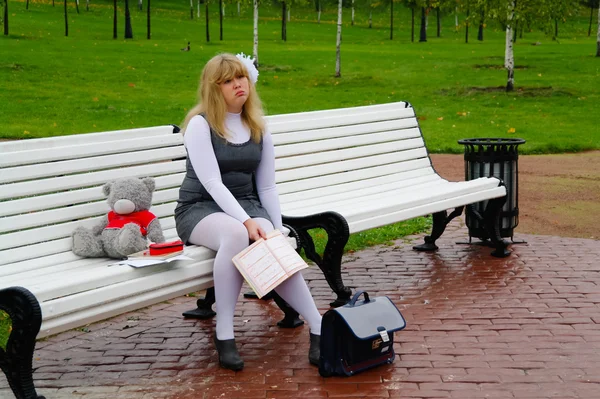坐在秋天的公园长椅上的女学生 — 图库照片
