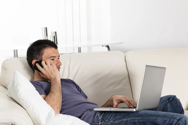 Telefon och laptop på soffa — Stockfoto