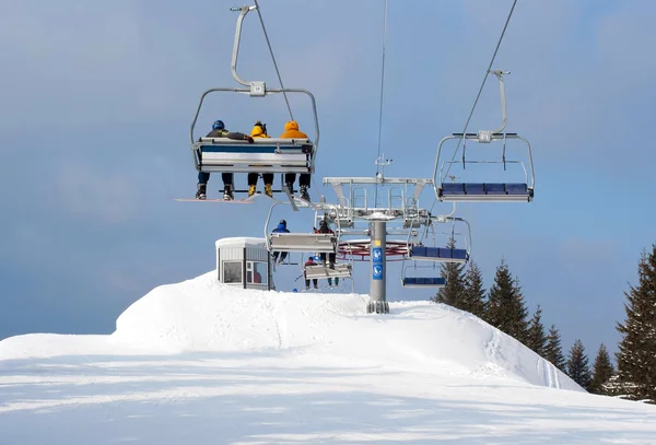 Skiërs in stoeltjeslift aankomen naar top van berg — Stockfoto