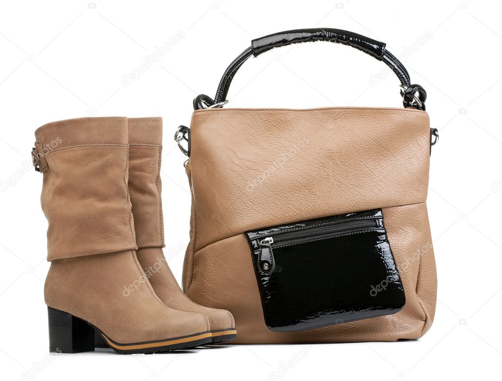 Pair of female boots and handbag over white
