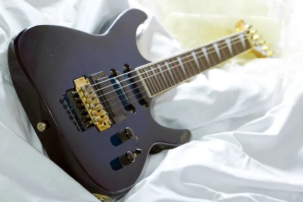 Guitarra en la cama — Foto de Stock