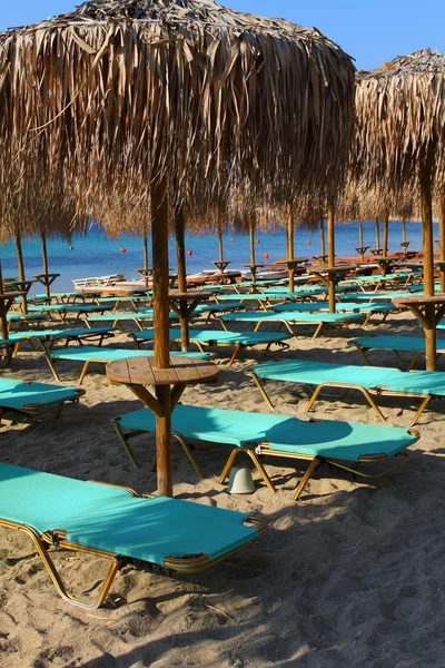 La playa cerca del mar azul con tumbonas y sombrillas —  Fotos de Stock