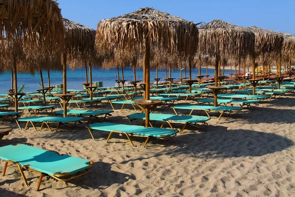 Der Strand am blauen Meer mit Liegestühlen und Sonnenschirmen — Stockfoto