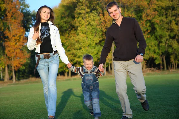 Familjen njuter av promenad i höst park — Stockfoto