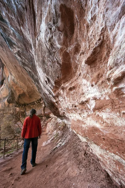 Turista caminando bajo la roca —  Fotos de Stock