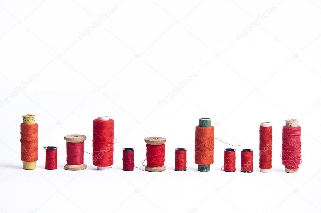 Different bobbins with red-colored sewing strings