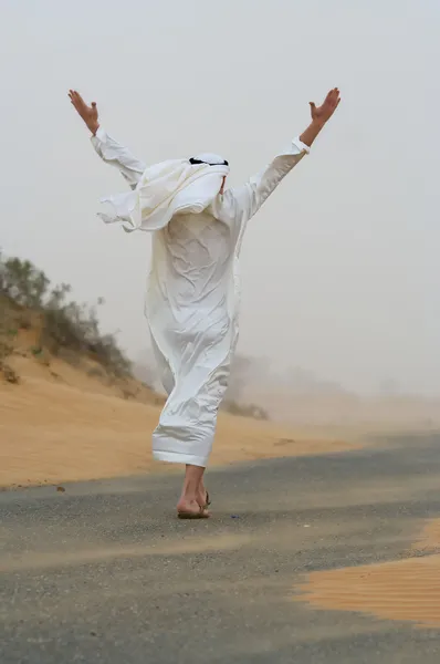 Arabiska mannen gå i sand storm Royaltyfria Stockfoton