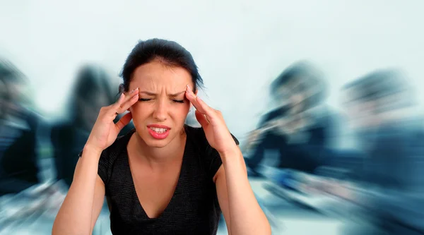 Vrouw deinende een hoofdpijn op het werk — Stockfoto