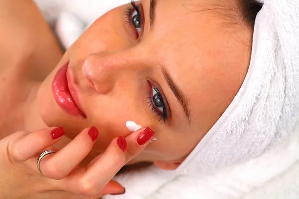 Vrouw aanbrengen hydraterende crème op haar gezicht — Stockfoto