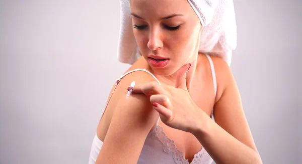Frau trägt Feuchtigkeitscreme auf ihren Körper auf — Stockfoto