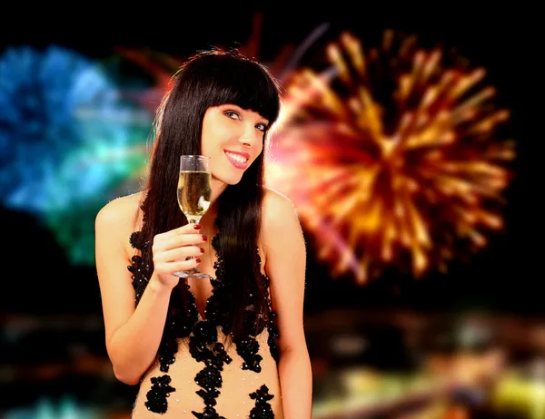 Mulher sexy com champanhe sobre fogos de artifício de fundo — Fotografia de Stock
