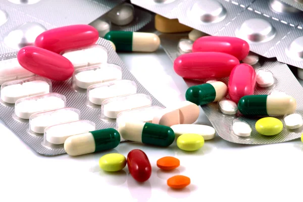 Таблетки разных форм и цветов, сгруппированные вместе — стоковое фото