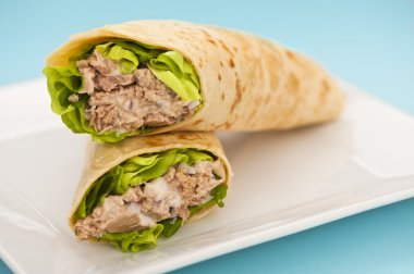 Two tuna melt wrap on a white plate clipart