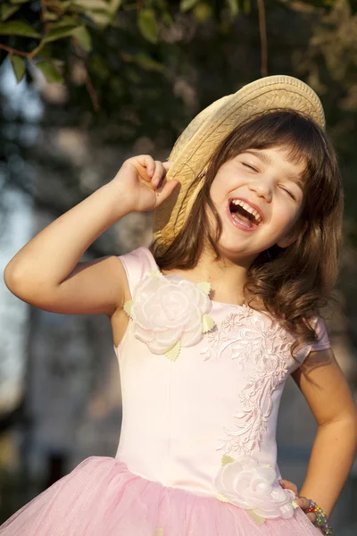 Roztomilý dívka je montáž slaměný klobouk — Stock fotografie