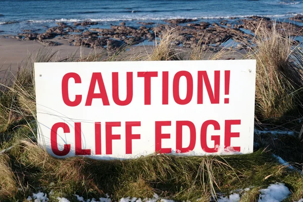 Značka červené varování na okraji útesu kluzké — Stock fotografie