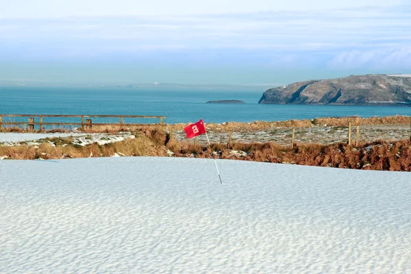Beyaz buz gibi kar golf sahası ve kayalıklarla kaplı — Stok fotoğraf