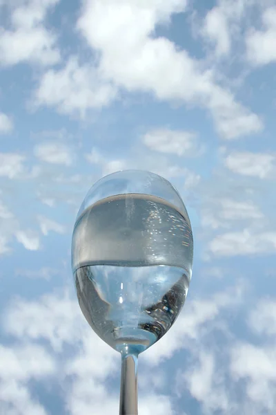Стакан прохладной воды против голубого неба — стоковое фото