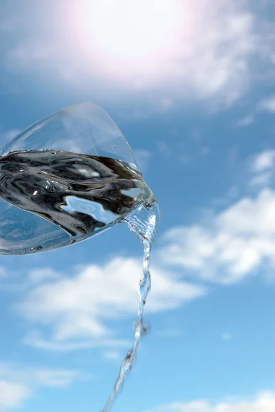 Un vaso de agua contra un cielo soleado — Foto de Stock