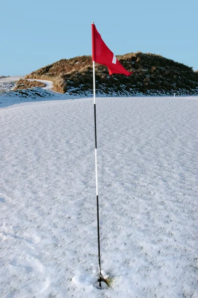 Sneeuw overdekte Verwijzigingen golfbaan rode vlag wapperend — Stockfoto