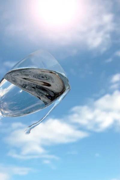 Gegossen Glas Wasser gegen einen sonnigen Himmel — Stockfoto