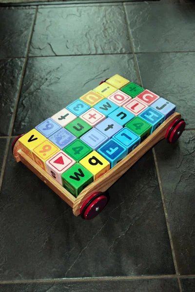 Chariot de jouets pour enfants et blocs de jeu de lettres — Photo