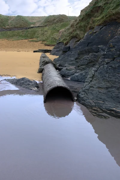 Rusty metal overflow seashore pipe — Stock Photo, Image