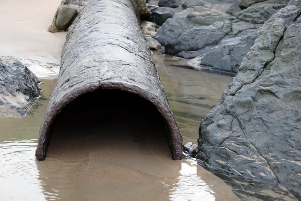 Tubo de desbordamiento oxidado en la orilla del mar — Foto de Stock