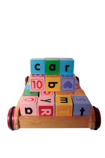 Childrens play blocks spell car in wooden cart isolated on white — Stock Photo, Image