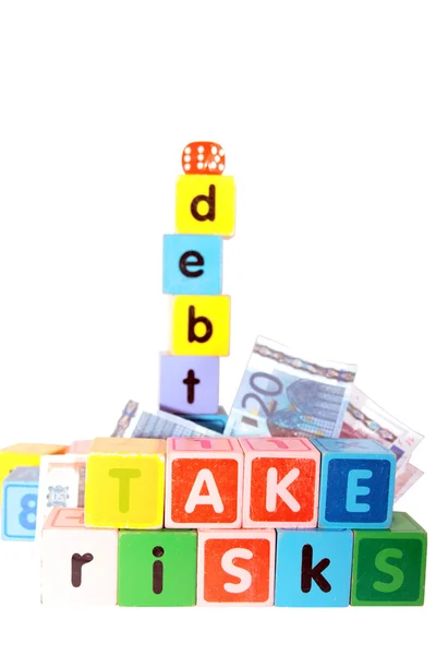 Take risks with debt in childs letter play blocks — Stock Photo, Image
