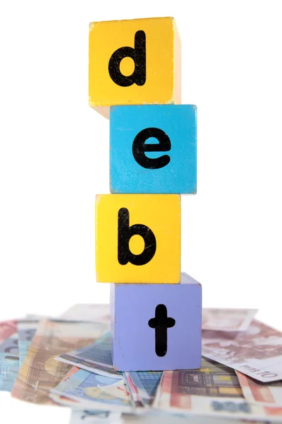 Dívida de dinheiro no brinquedo jogar letras de bloco — Fotografia de Stock