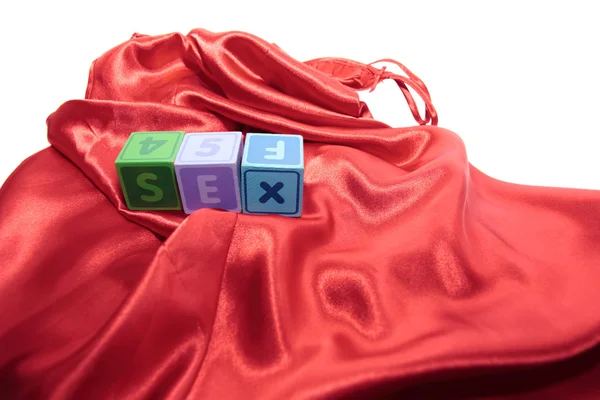 Sex on letter cubes on silk nightie — Stock Photo, Image