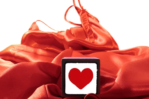 Toy love heart on silk nightie — Stock Photo, Image