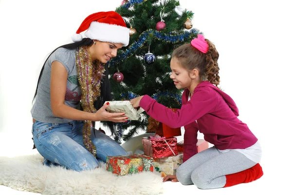 Мати і дочка біля ялинки з подарунками, ізольовані на білому б — стокове фото
