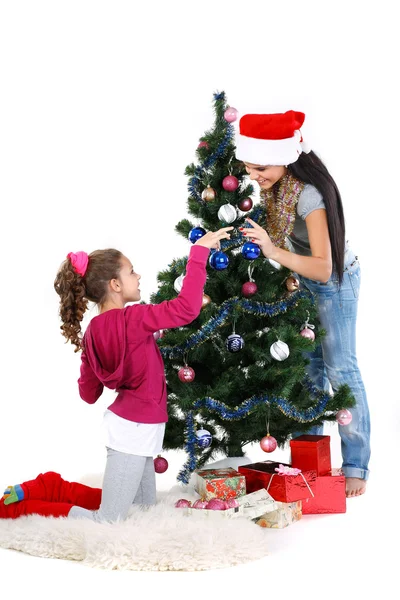 Madre e hija cerca de un árbol de navidad con regalos, aisladas en una b blanca —  Fotos de Stock