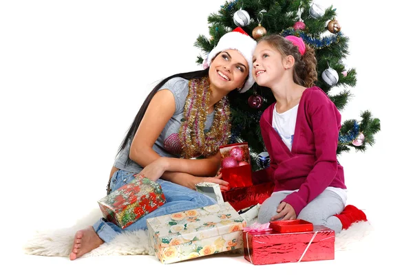 Matka a dcera v blízkosti vánoční stromeček s dárky, izolovaných na bílém b — Stock fotografie